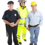 Group of blue collar workers isolated on white, including a firefighter, police officer, and construction worker.